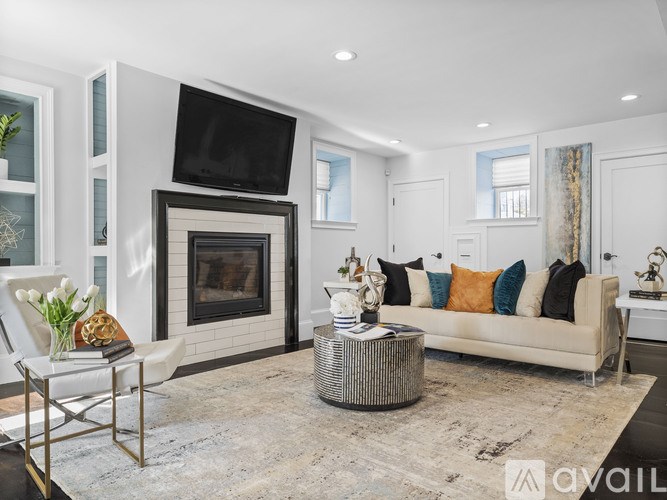 A modern living room with a fireplace and a television mounted above it.