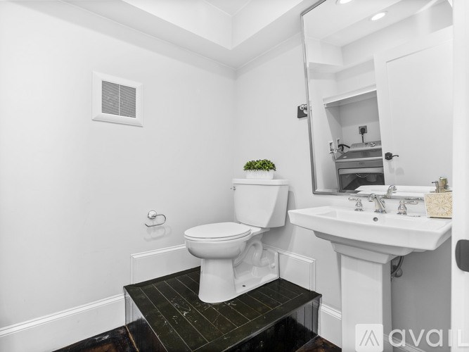 A white toilet sits in a bathroom next to a sink.