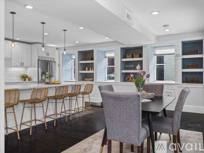 A modern kitchen with a bar area and dining table.