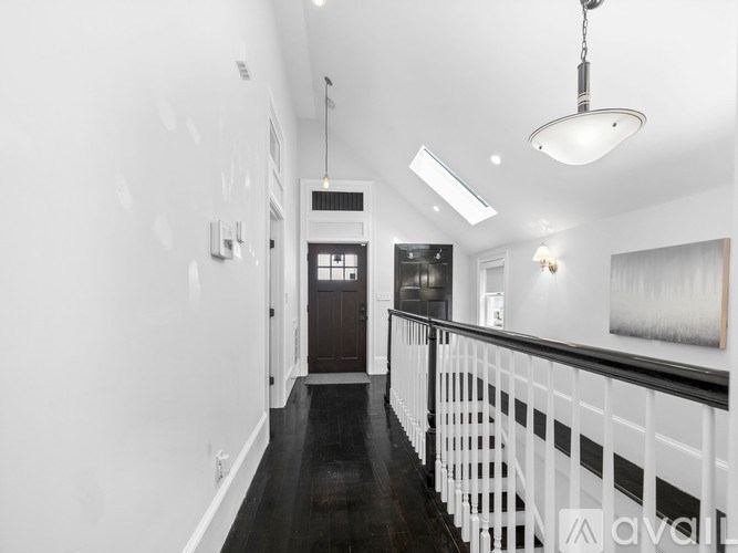 A long hallway with a black floor and white walls.