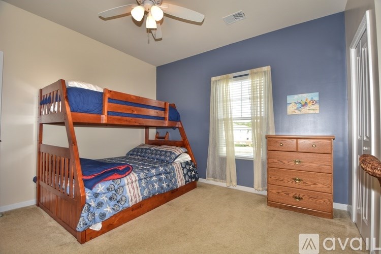 A bedroom with a bunk bed and a dresser.