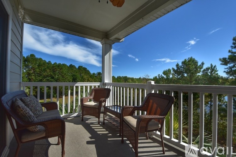 A porch with two chairs and a couch.