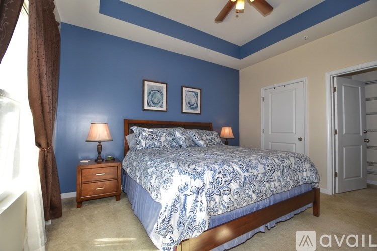 A bedroom with blue walls and a bed with a blue and white comforter.