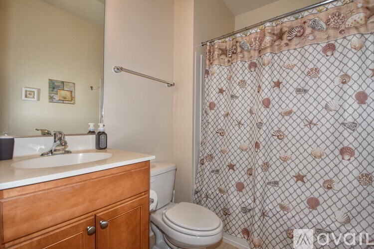 A bathroom with a toilet, sink, and shower curtain.