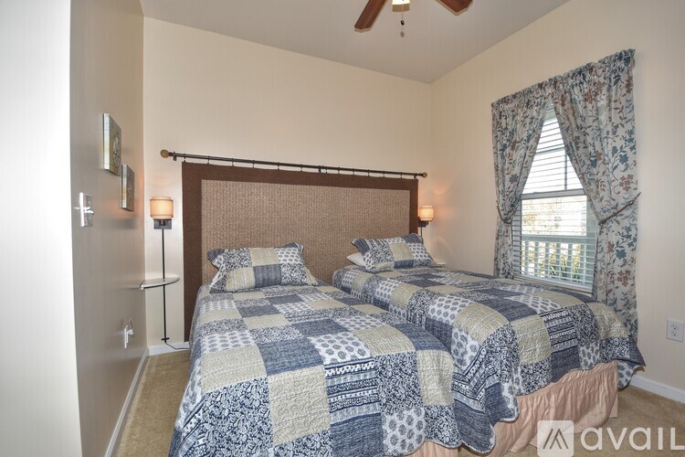 A bedroom with two beds and a ceiling fan.