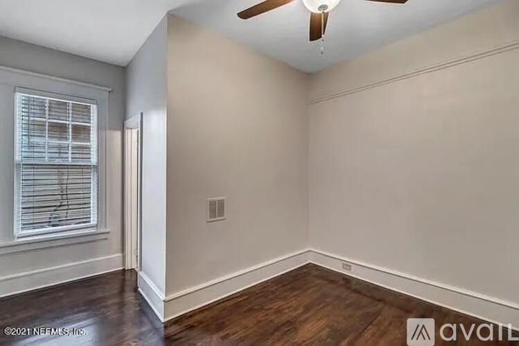 A room with a ceiling fan and a window with blinds.