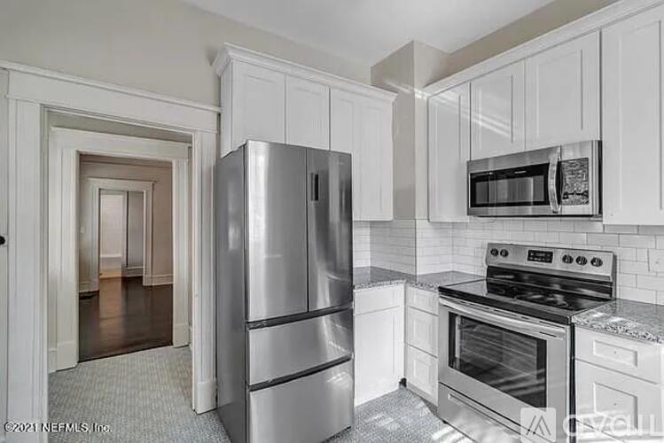 A kitchen with white cabinets and stainless steel appliances.