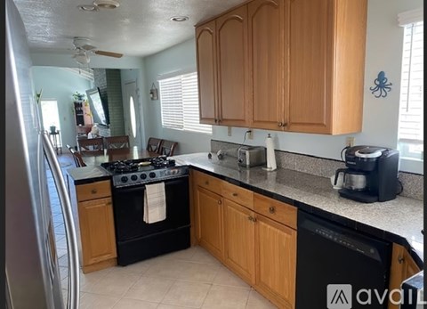A kitchen with wooden cabinets and black appliances.