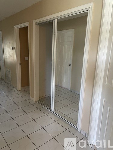 A hallway with a tiled floor and white walls.