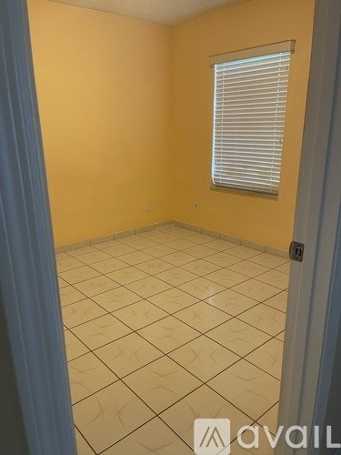 A room with yellow walls and a tile floor.