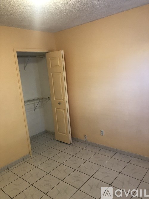 A room with a door and a wall socket.