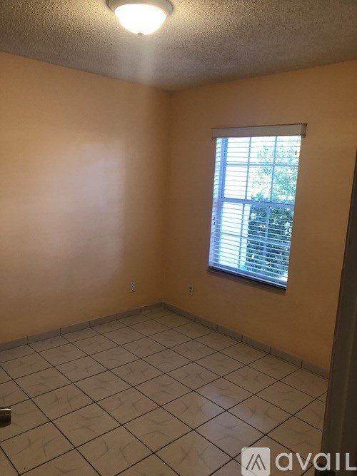 A room with a window and tiled floor.