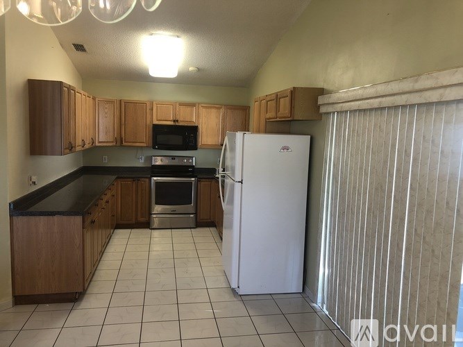 A kitchen with a white fridge and wooden cabinets.