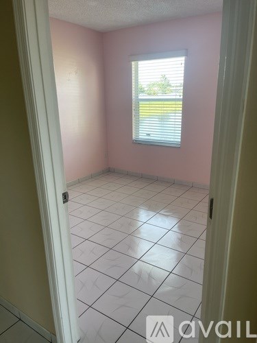 A room with a window and tiled floor.