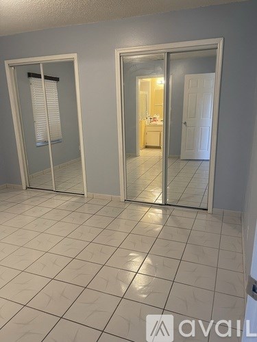 A room with a tiled floor and a mirrored door.