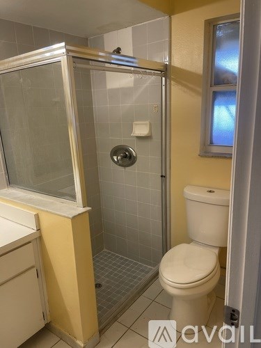 A bathroom with a toilet, sink, and shower.