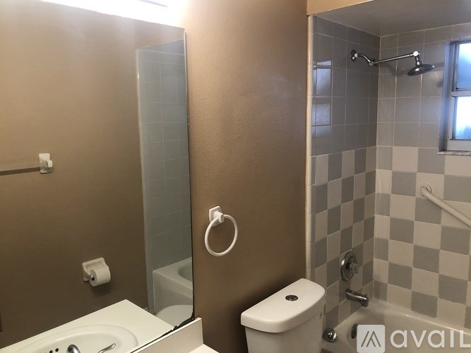 A bathroom with a toilet, sink, and shower.