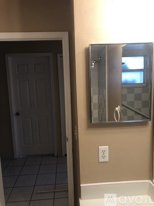 A bathroom with a mirror and a door.