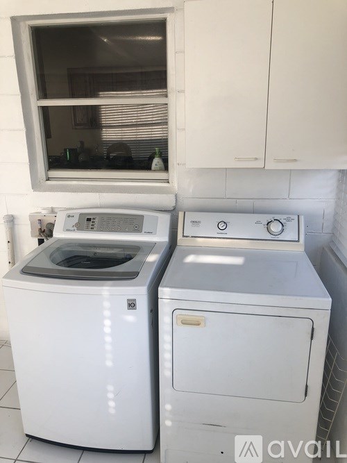 A white washing machine and dryer in a kitchen.