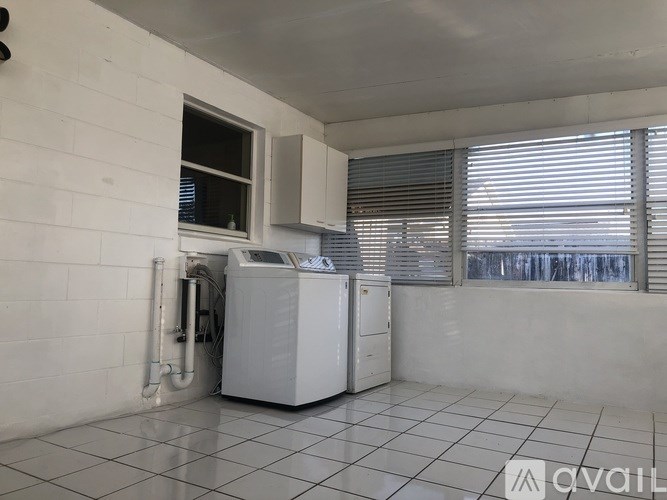 A white room with a fridge and a washing machine.