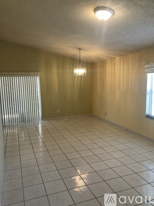 A room with a tiled floor and a chandelier hanging from the ceiling.
