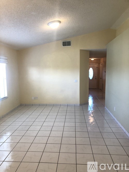A room with a tiled floor and a doorway leading to another room.