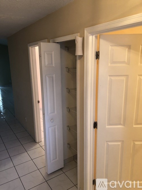 A hallway with two doors, one of which is open.