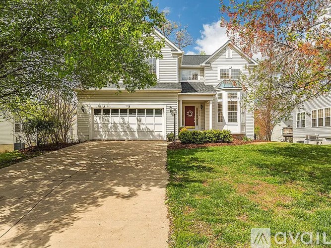 A house with a driveway and a red door.