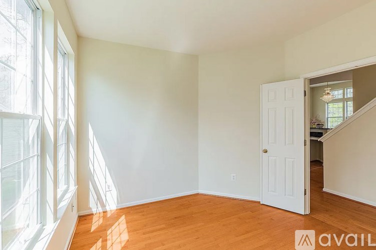A room with a white door and a window with sunlight coming through.