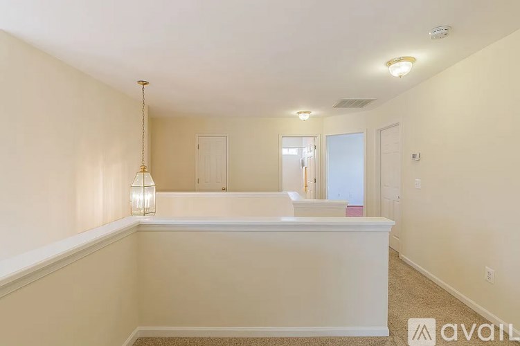 A well-lit room with a carpeted floor and a white reception desk.