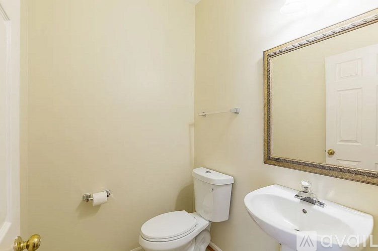 A white toilet sits next to a white sink in a bathroom.