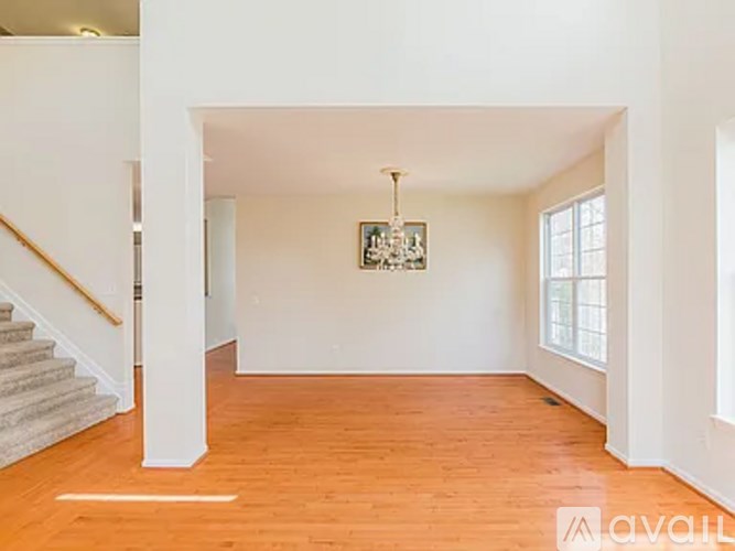 A room with wooden floors and a chandelier hanging from the ceiling.
