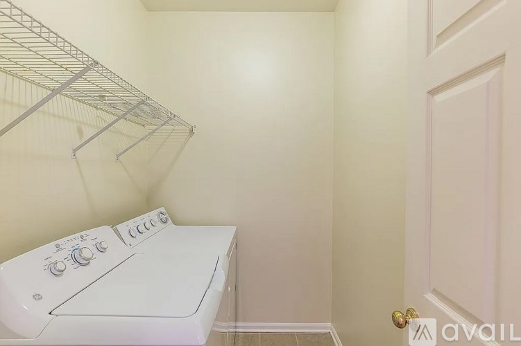 A white dryer is sitting in a small laundry room.