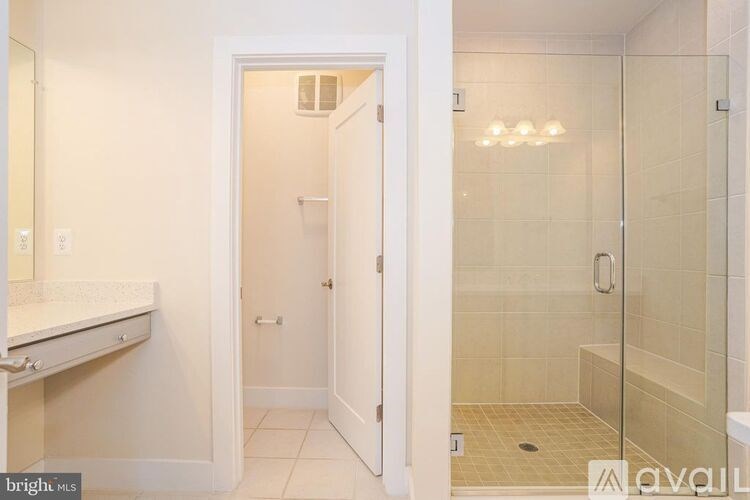 A bathroom with a walk-in shower and a white door.