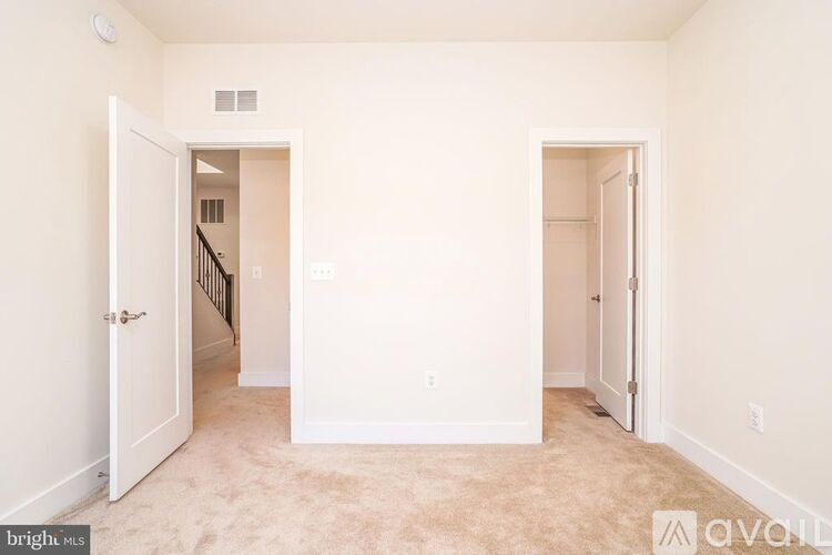 A room with two doors and a staircase in the background.