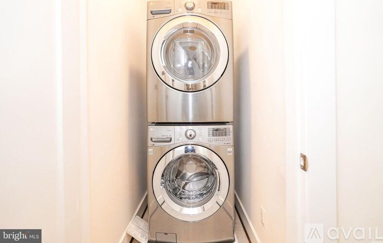 A front-loading washing machine with a clear door and a control panel with buttons and a digital display.