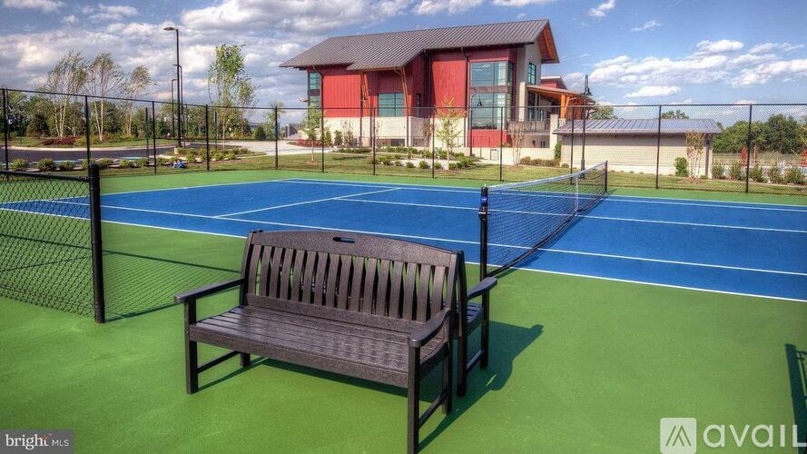 A wooden bench sits on a tennis court.