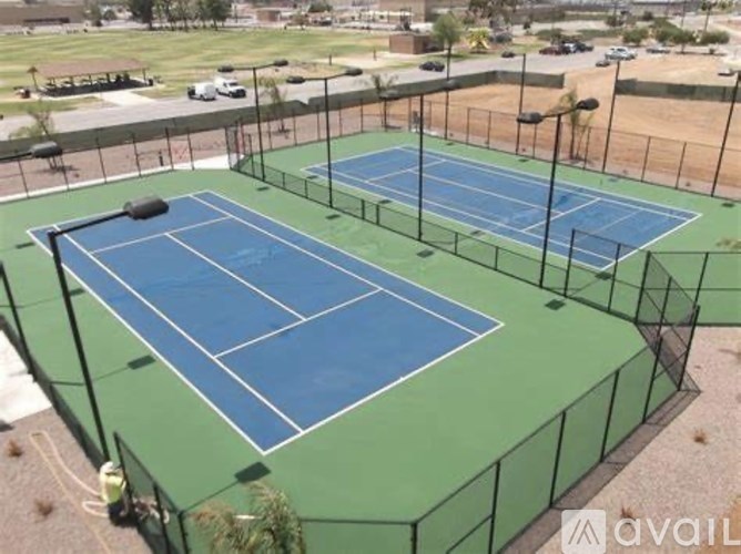 A tennis court with a blue surface and green border.