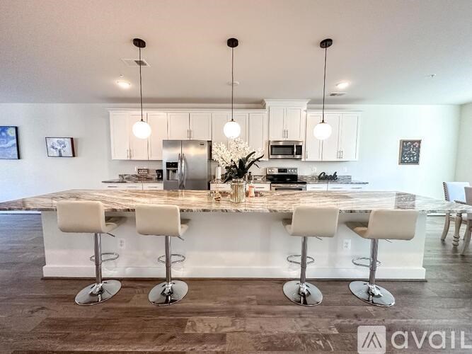 A modern kitchen with a large island and bar stools.