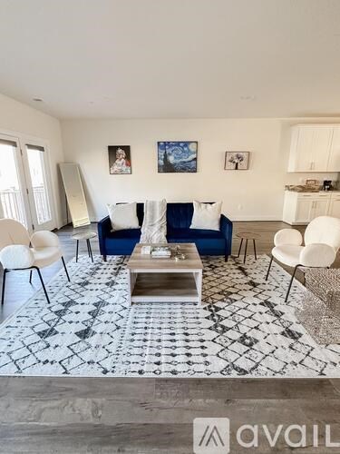 A living room with a patterned rug and a coffee table.