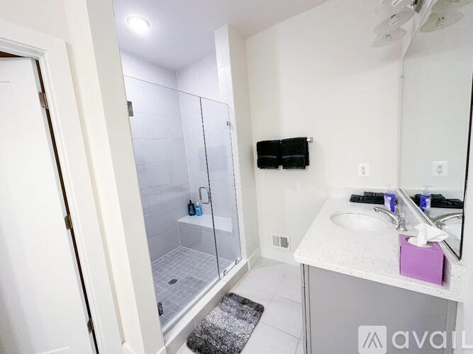 A bathroom with a sink, mirror, and shower.