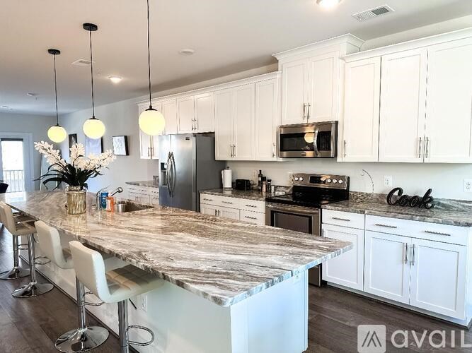 A kitchen with a marble countertop and white cabinets.