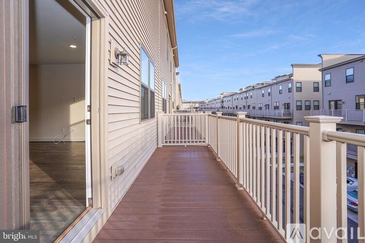A balcony with a wooden floor and white railings.