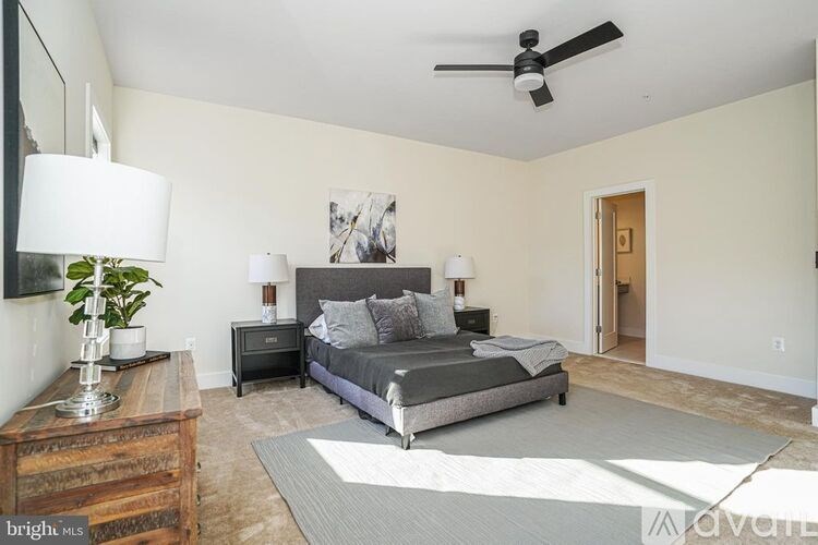A bedroom with a bed, nightstands, and a ceiling fan.