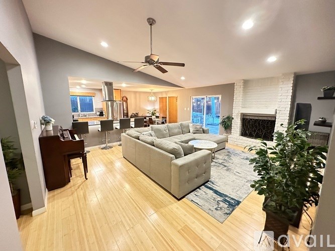 A living room with a couch, a table, and a fireplace.