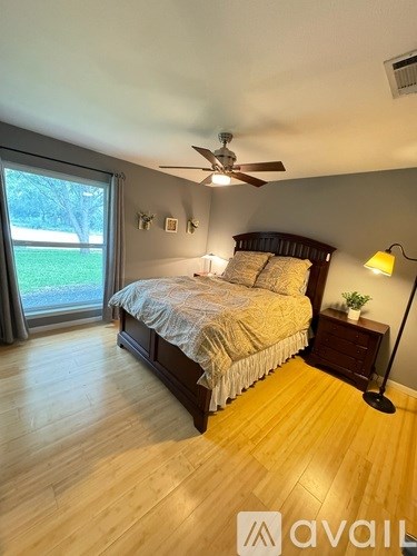 A bedroom with a bed, nightstand, and sliding glass doors.