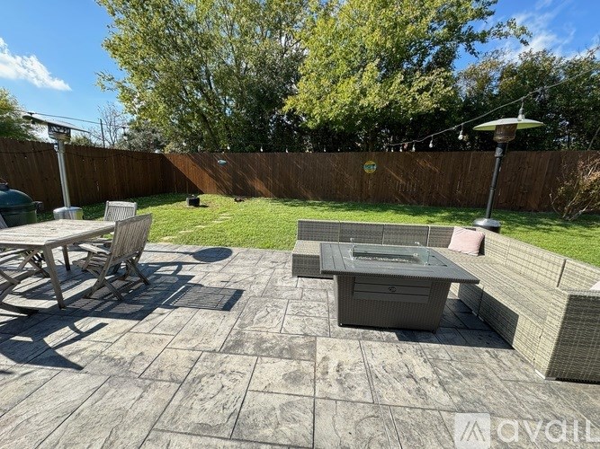 A backyard with a patio table and chairs.