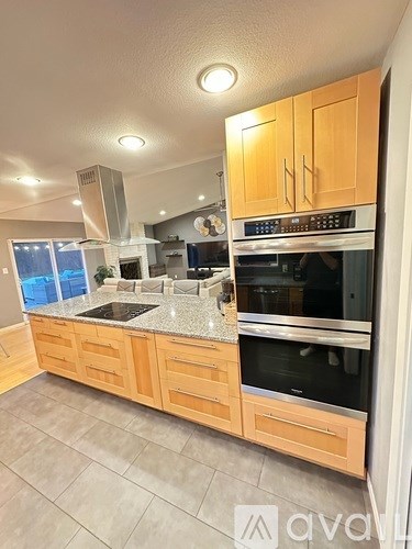 A kitchen with wooden cabinets and a granite countertop.