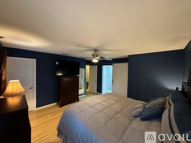 A bedroom with a bed, nightstand, and lamp.