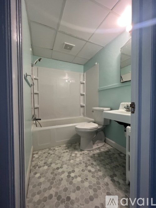 A bathroom with a toilet, sink, and bathtub.